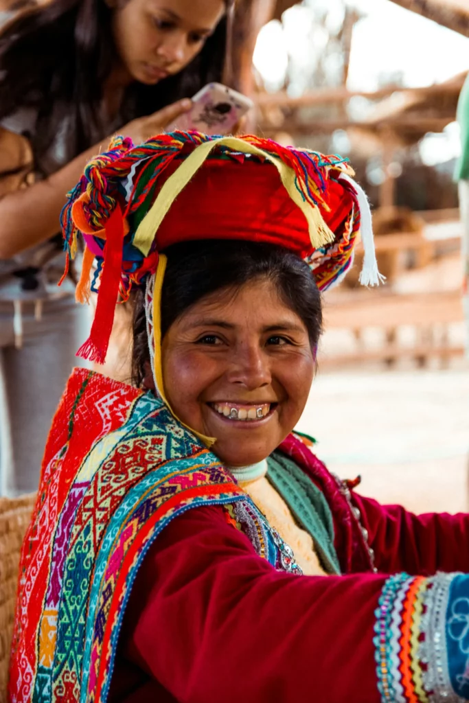 Femme péruvienne en tenue traditionnelle colorée, souriante dans un marché artisanal andin, illustration authentique pour un travel planner au Pérou.