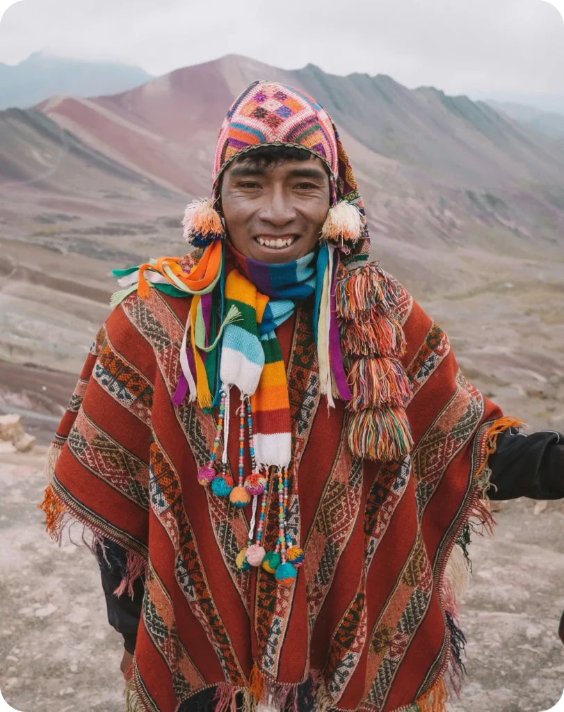 Portrait d’un habitant des Andes en tenue traditionnelle devant la montagne Vinicunca au Pérou, capturé lors d’un voyage organisé par un travel planner expert en immersion culturelle.
