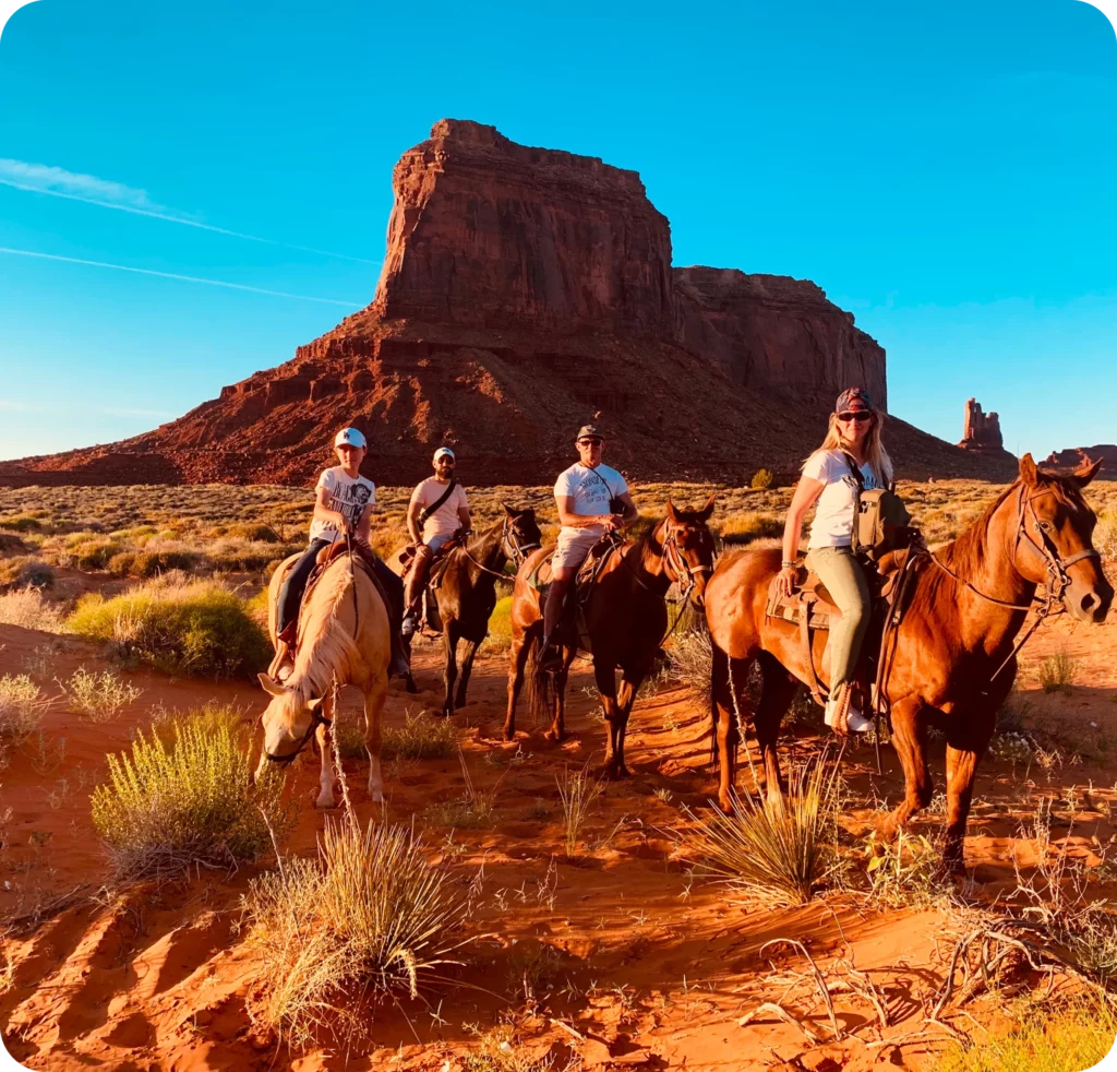 Balade à cheval en famille dans le désert rouge de Monument Valley, une expérience unique incluse dans un itinéraire de voyage personnalisé à travers l’Ouest américain.