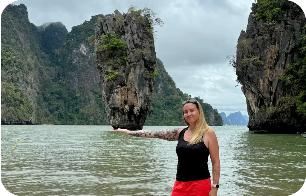 Travel planner posant devant James Bond Island en Thaïlande, célèbre formation rocheuse au cœur de la baie de Phang Nga, destination prisée pour les voyages sur mesure.
