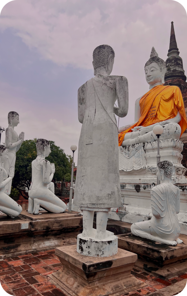 Statues bouddhistes en position de prière dans un temple thaïlandais, étape spirituelle d’un itinéraire culturel conçu par un travel planner spécialisé en voyages authentiques en Asie.