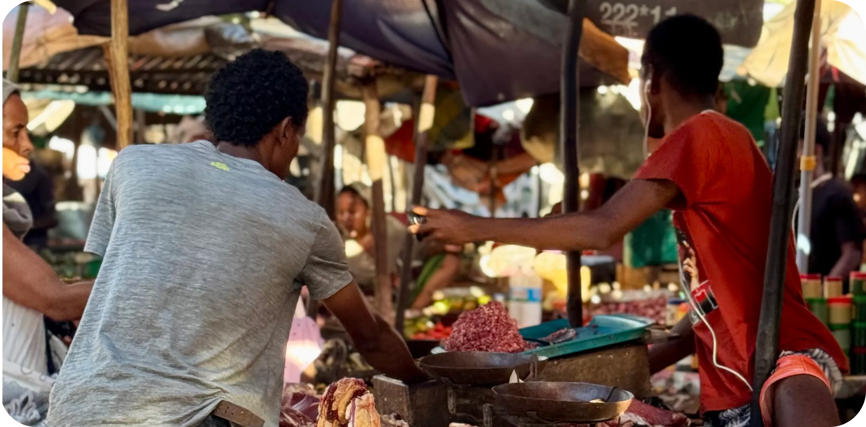 Scène de vie sur un marché traditionnel africain avec échanges entre vendeurs et clients, immersion authentique incluse dans un itinéraire de voyage personnalisé axé sur les rencontres locales.