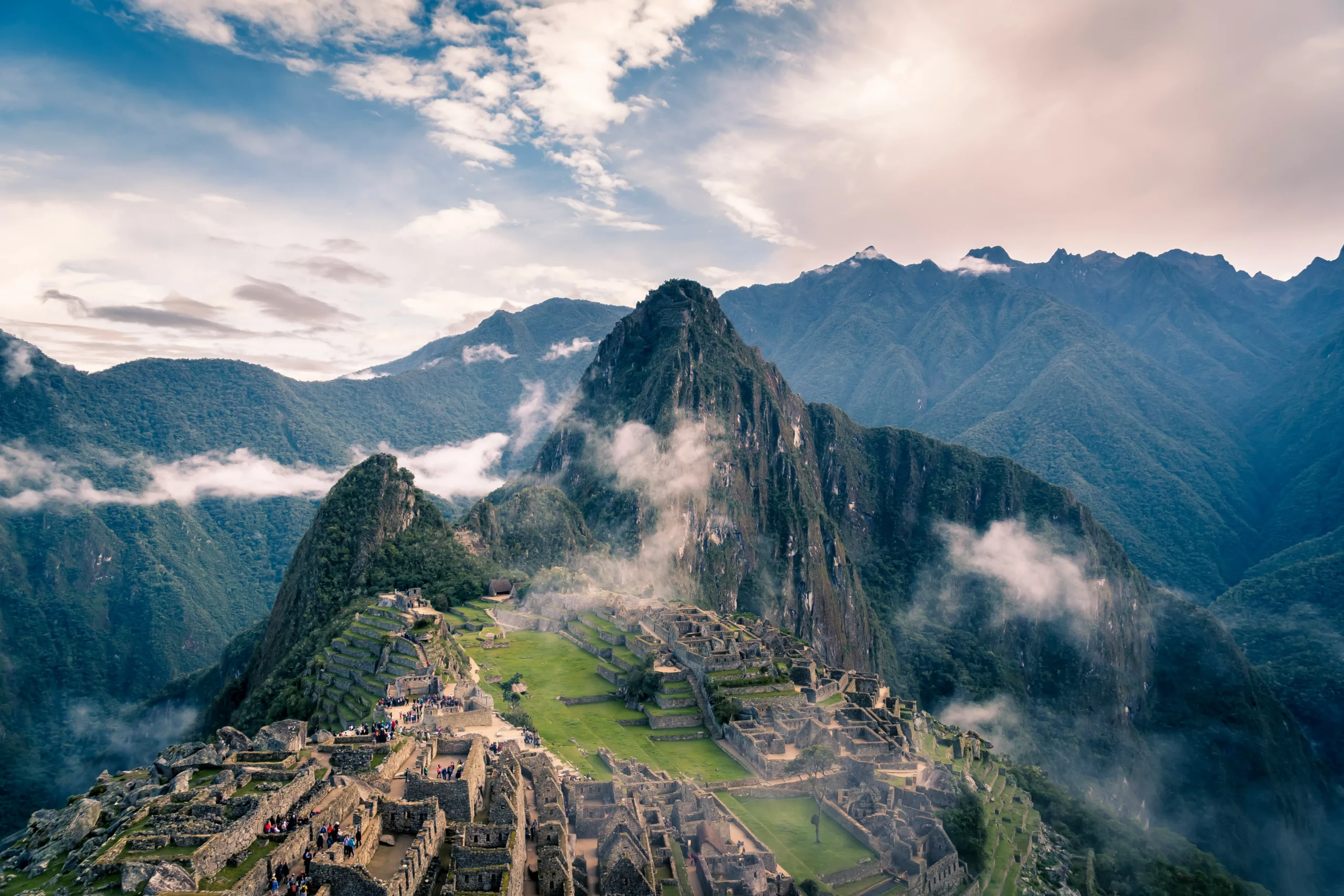 Vue aérienne du Machu Picchu entouré de brume et de montagnes verdoyantes, site incontournable à inclure dans un travel planner au Pérou pour une immersion historique et naturelle.